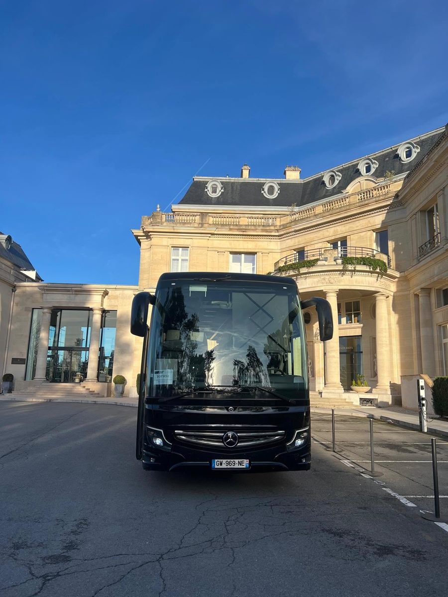 Autocar Les Coordinateurs devant un château-hôtel